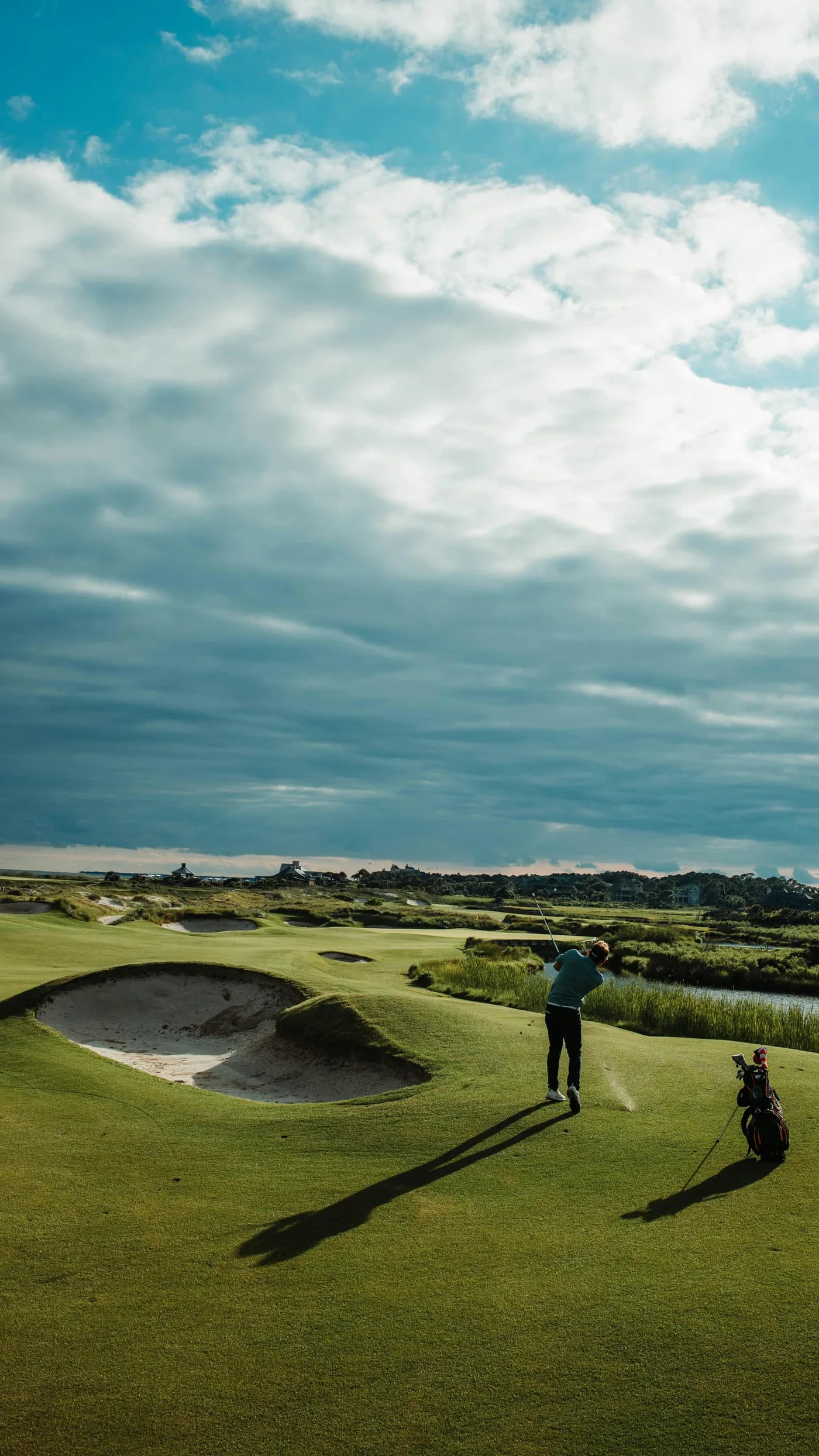 Golfare svingar vid bunker